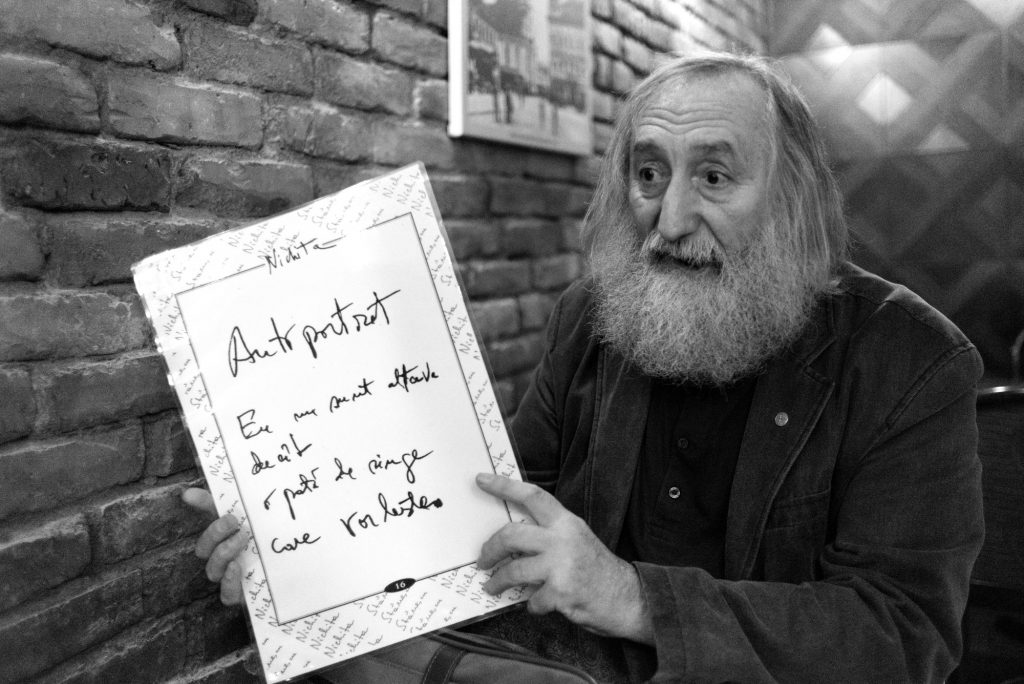 Adam Puslojić ține în mână o copie plasticată a primului Autoportret scris de Nichita Stănescu, direct pe un album al poetului sârb